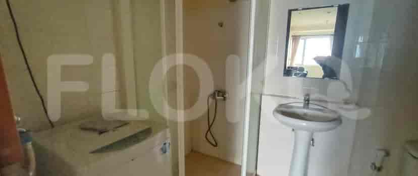 A bathroom featuring a shower stall, washing machine, and sink with a mirror.