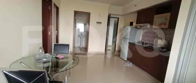 A kitchen with dining table, appliances, and entrance to other rooms.