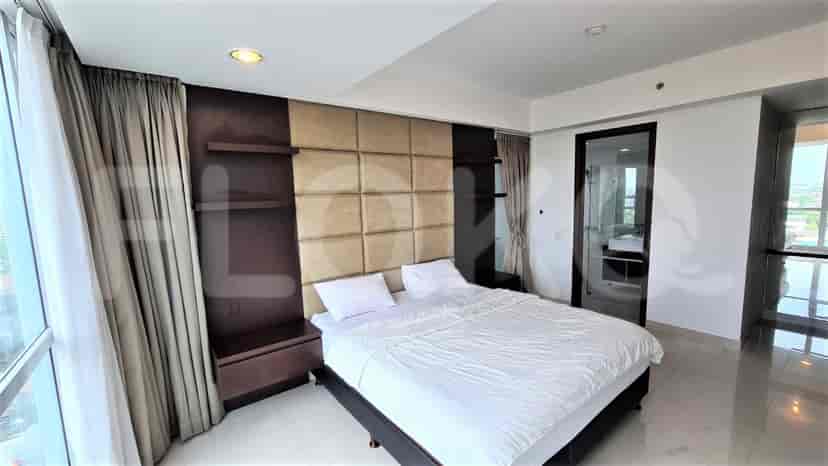 Master bedroom with a large bed, padded headboard, and bedside cabinets.