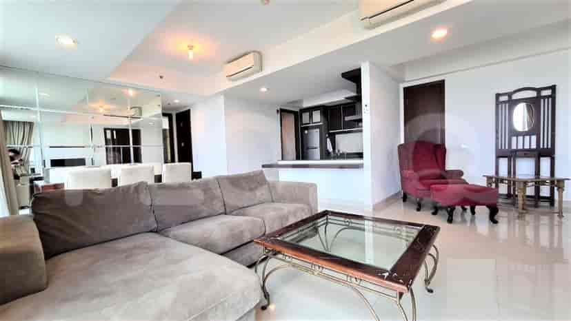 Open plan living area with a sofa, dining area, and kitchen, offering a bright, airy feel.