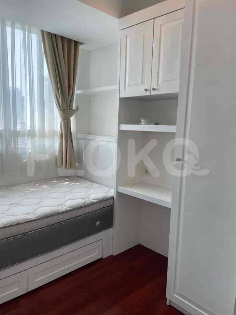 Bedroom with bed, desk, and built-in storage.
