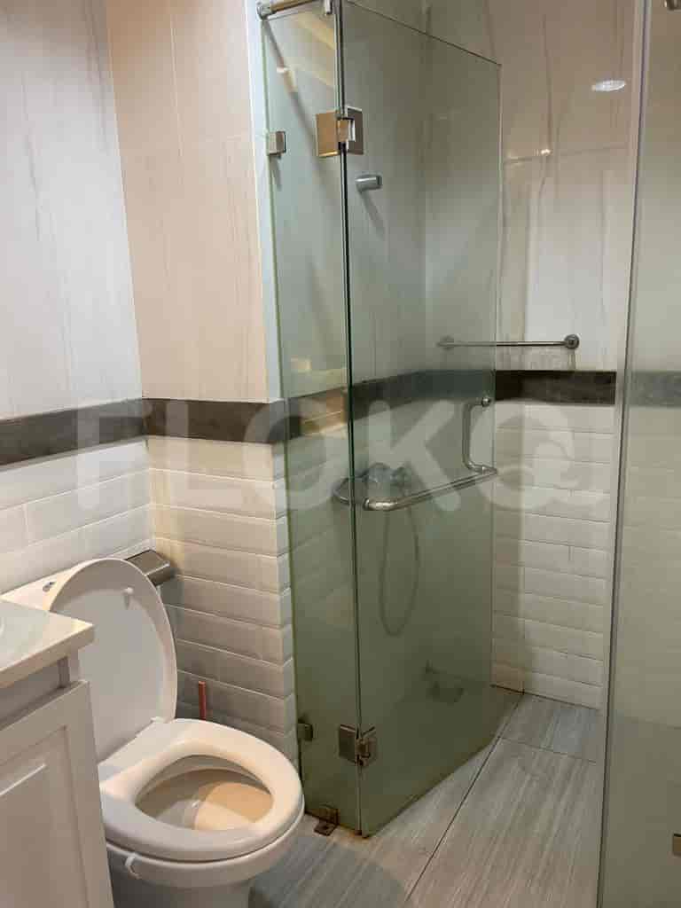 The bathroom has a glass shower, a toilet, and a modern design.