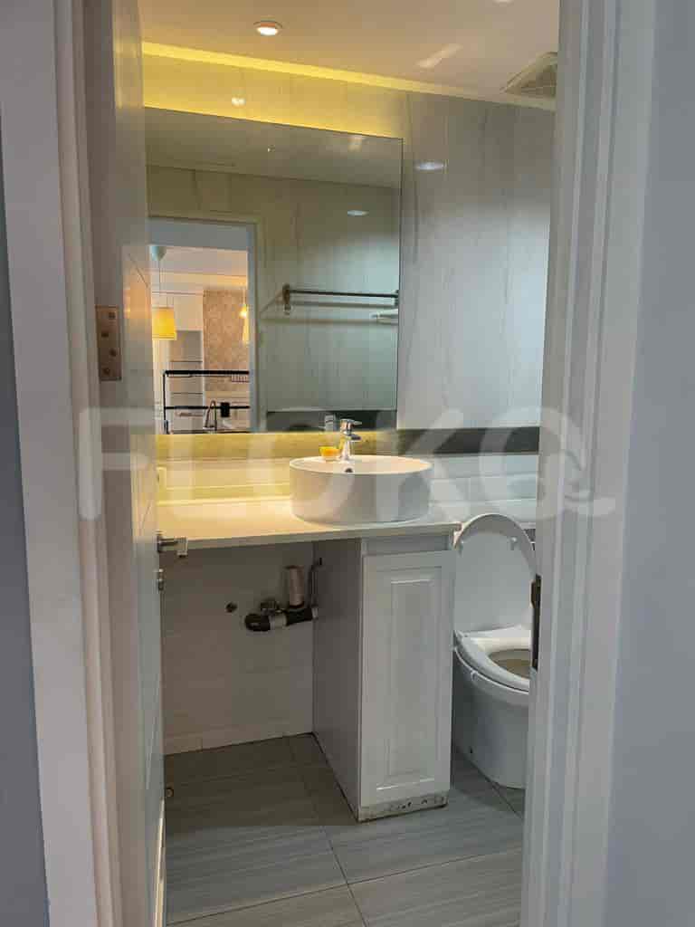 Bathroom with a round sink, mirror, and white cabinet.