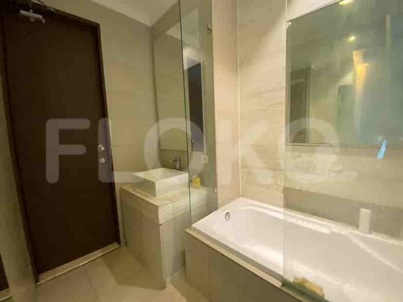 Modern bathroom with a bathtub, glass shower divider, and large mirror.