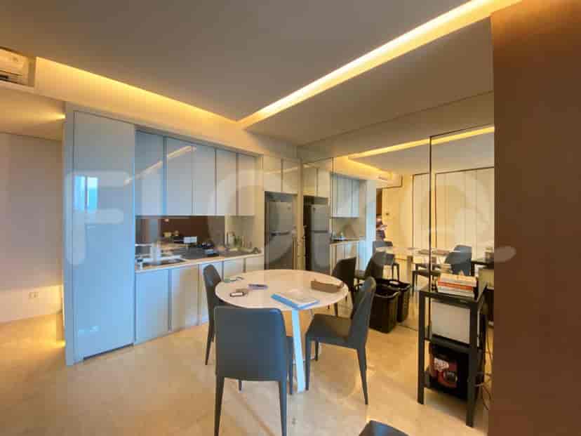 Open-plan kitchen and dining area with modern appliances, a round dining table, and built-in cabinets.