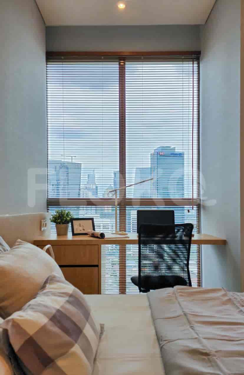 Bedroom with a desk, a window with blinds, and a bed.