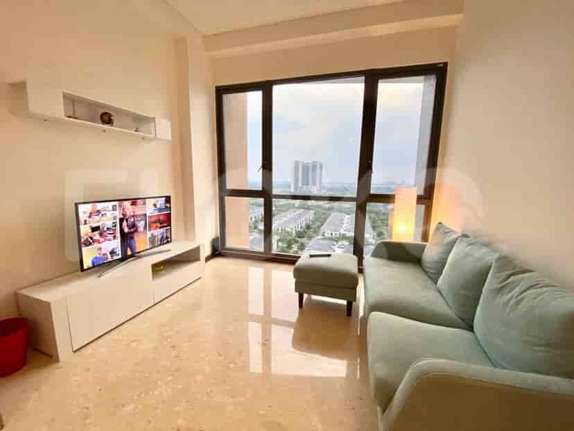 Pemandangan ruang tamu dengan TV, ottoman, dan sofa dengan pemandangan kota.