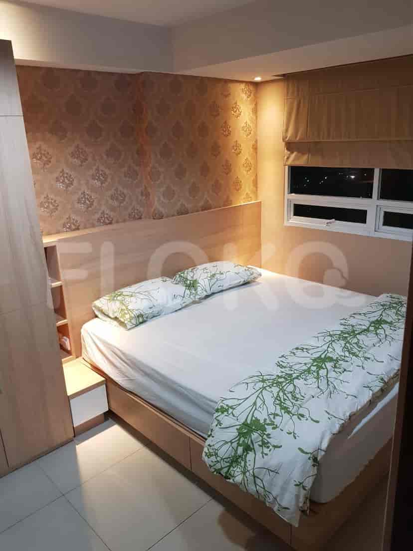 A bedroom with a bed, wooden headboard, and a cabinet.