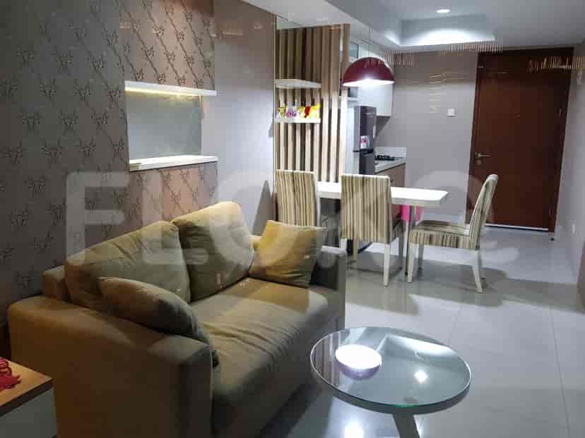 A living room with a sofa and a dining area with a table and chairs.