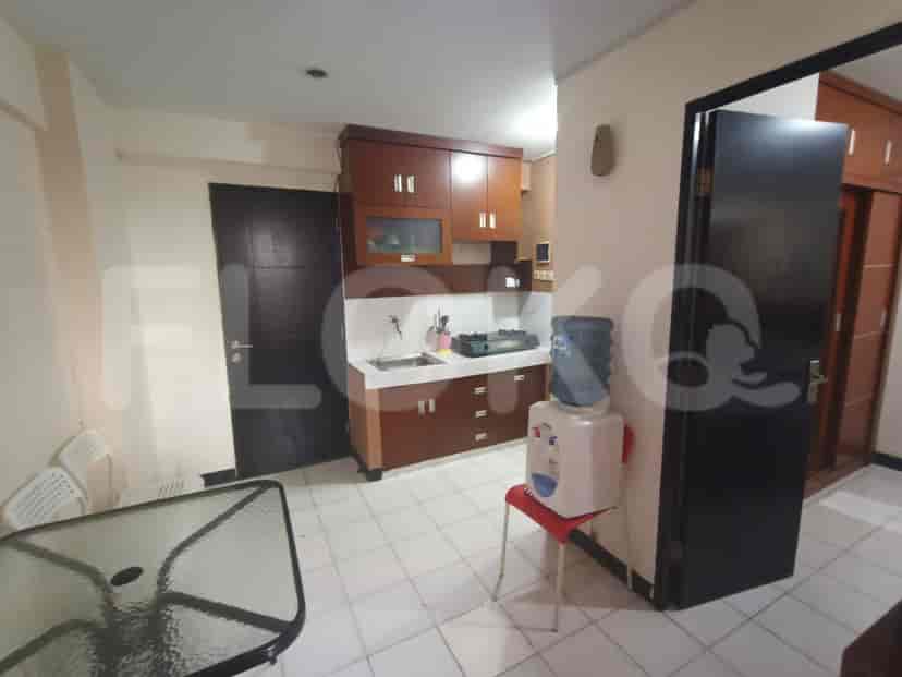 Area tempat tinggal dan dapur gabungan dengan dispenser air dan meja.