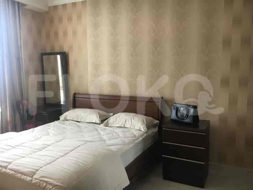 A bedroom featuring a bed, dressing table, and a nightstand.
