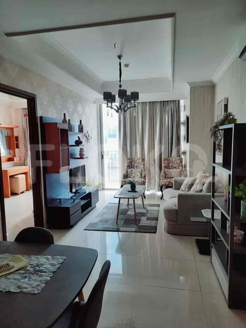 A living room with a sofa, TV, and access to a balcony.