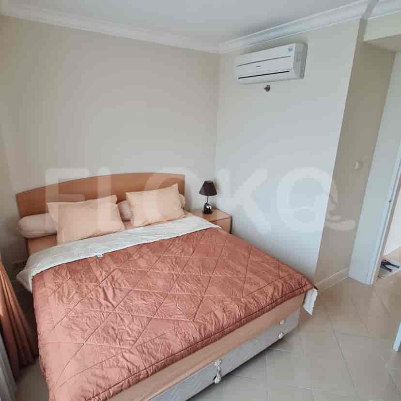 A bedroom with a bed, nightstand, and air conditioning.
