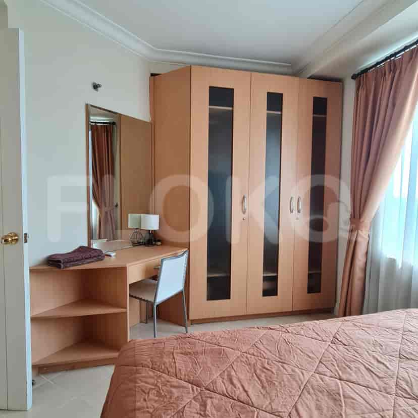 A bedroom with a bed, desk and closet.