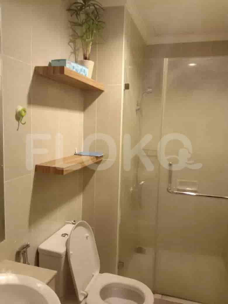 A clean bathroom with a toilet, shower, and shelves.