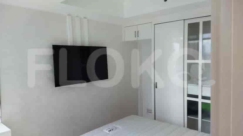 Kamar tidur lain dengan TV, lemari, dan tempat tidur.