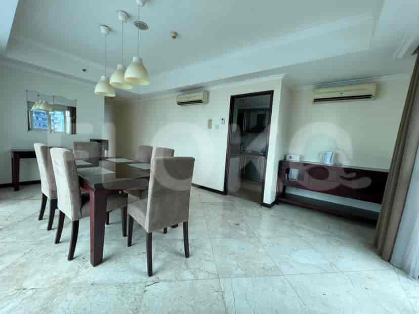 A dining area with a long dining table and chairs.