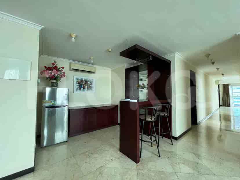 A dining area with a bar and an open kitchen concept.