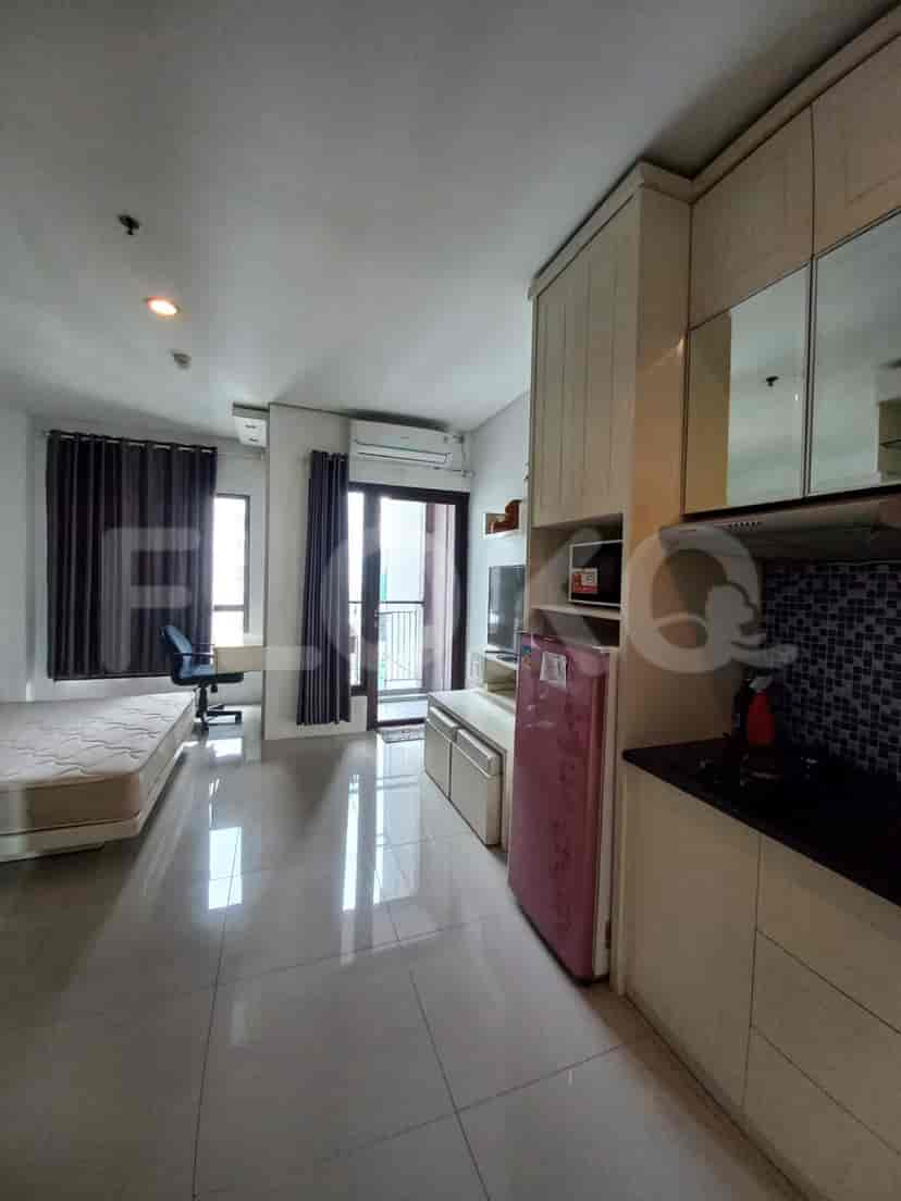Bedroom with kitchenette, including a bed, refrigerator, and kitchen amenities.
