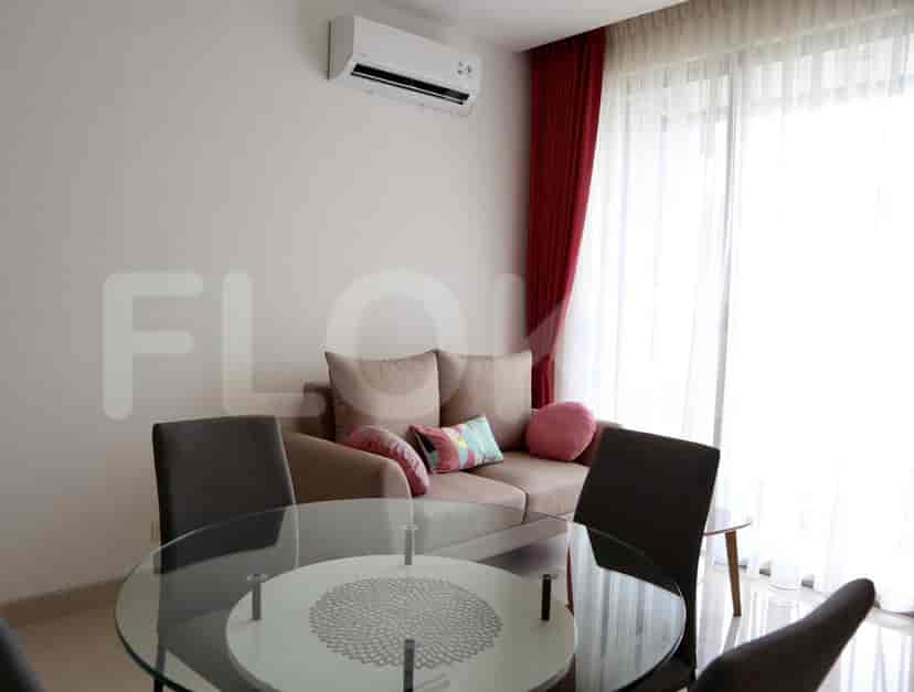 A living room with a sofa, round table with chairs, and large windows.