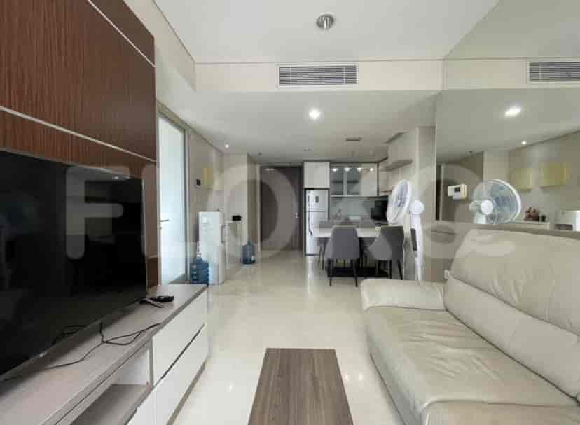 Spacious living room with a large smart TV, light-colored sofa, and open access to the dining and kitchen areas.