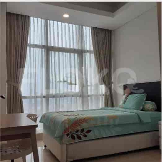 A bedroom with a single bed near a large window, and a simple desk.