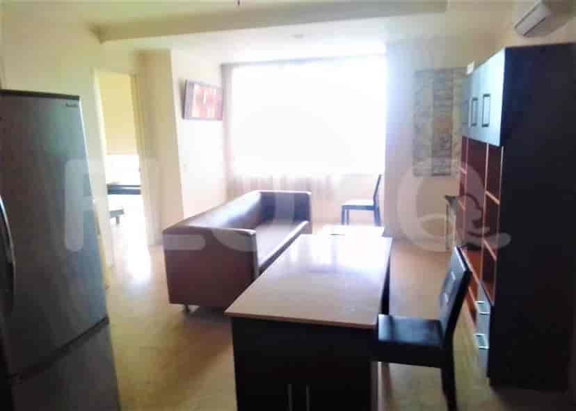 Ruang tamu dengan sofa, meja dapur, dan lemari es.