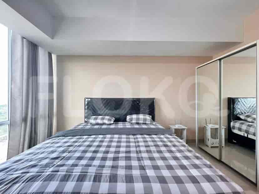 Kamar tidur dengan tempat tidur kotak-kotak, lemari, dan pemandangan kota.