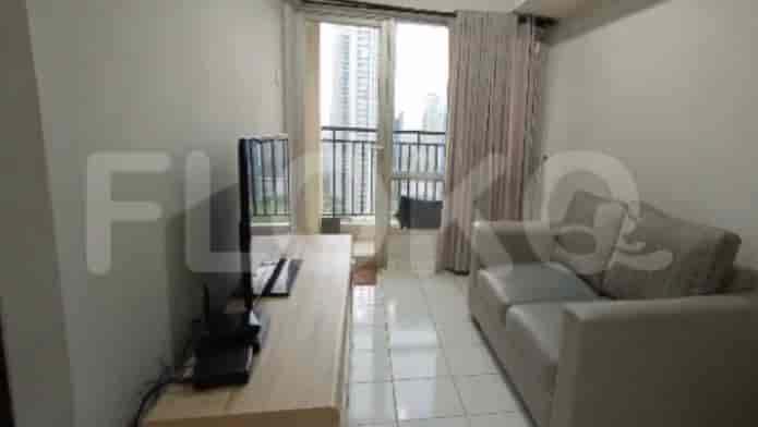 Living room with sofa, TV, and balcony.