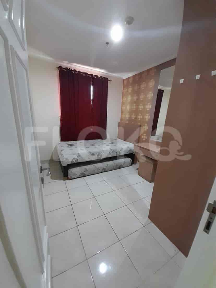Kamar tidur yang menampilkan tempat tidur ganda dan meja rias.