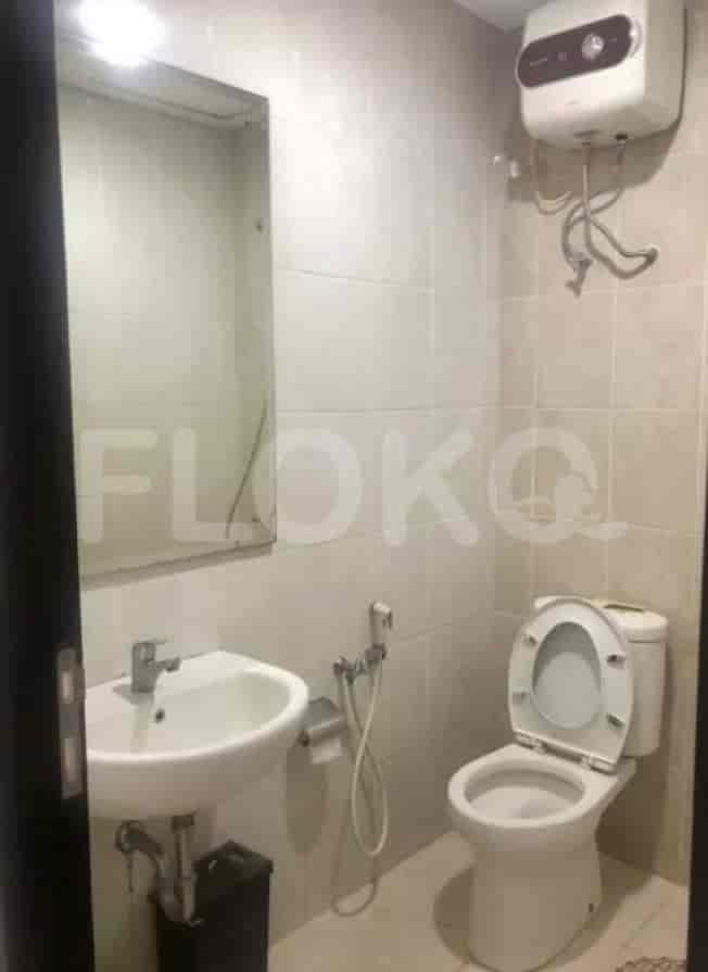 A compact bathroom with a toilet, sink, and water heater.