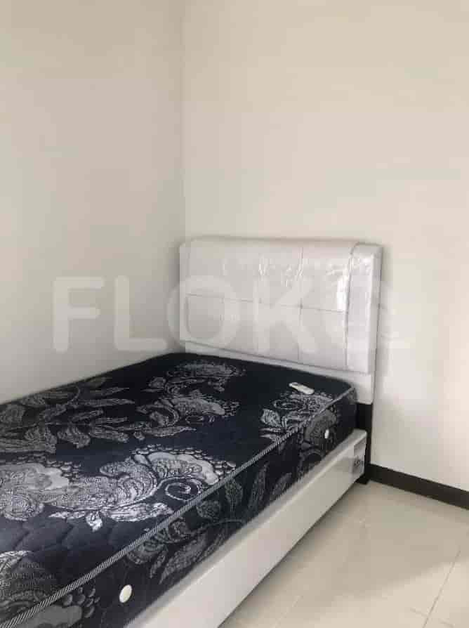 A small bedroom with a single bed and white walls.