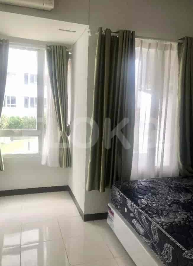 Bedroom with window, curtains, and bed.