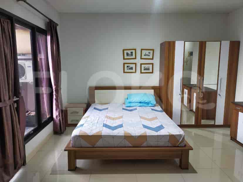 Bedroom interior with a bed, wardrobe, and window.