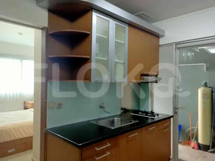 Dapur kecil yang bergaya dengan lemari kayu, wastafel baja tahan karat, dan kompor gas.