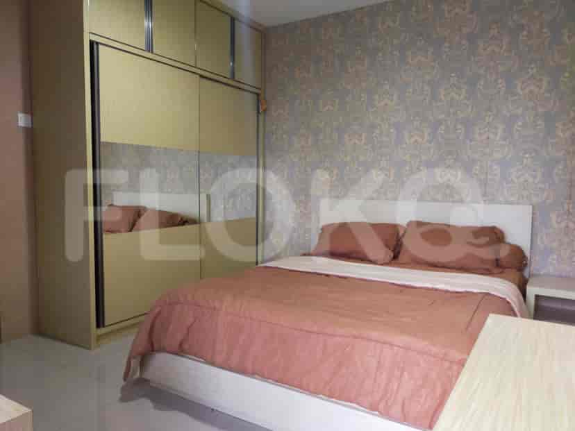 A bedroom featuring a bed, wardrobe with a mirror, and patterned wallpaper.