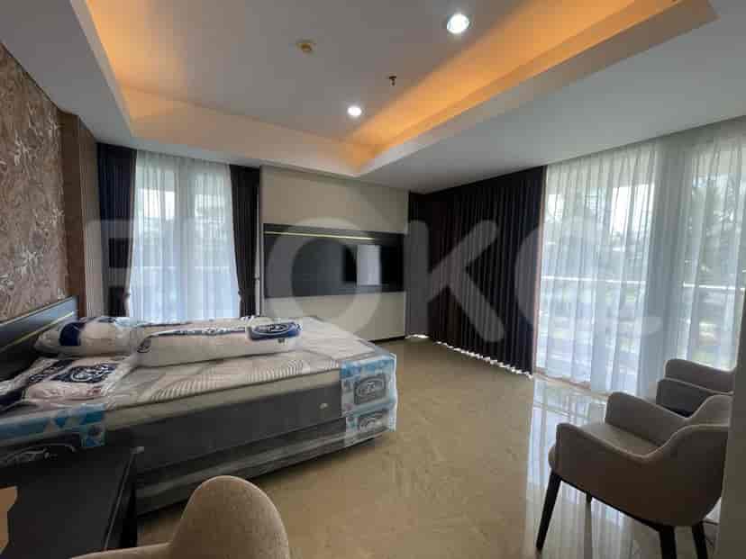 A bedroom with a bed, seating area, and balcony access.