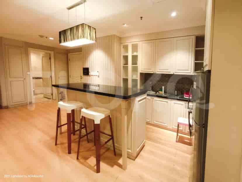A modern kitchen with a bar and stools.