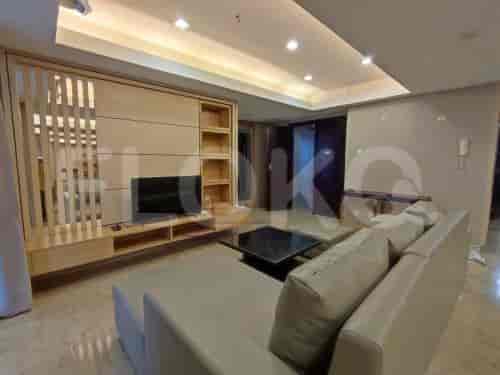 A living room with a sofa, TV, and wooden paneling.