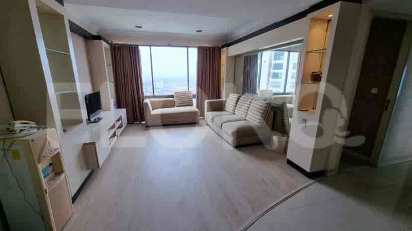 A living room with a sofa, TV, and large window.
