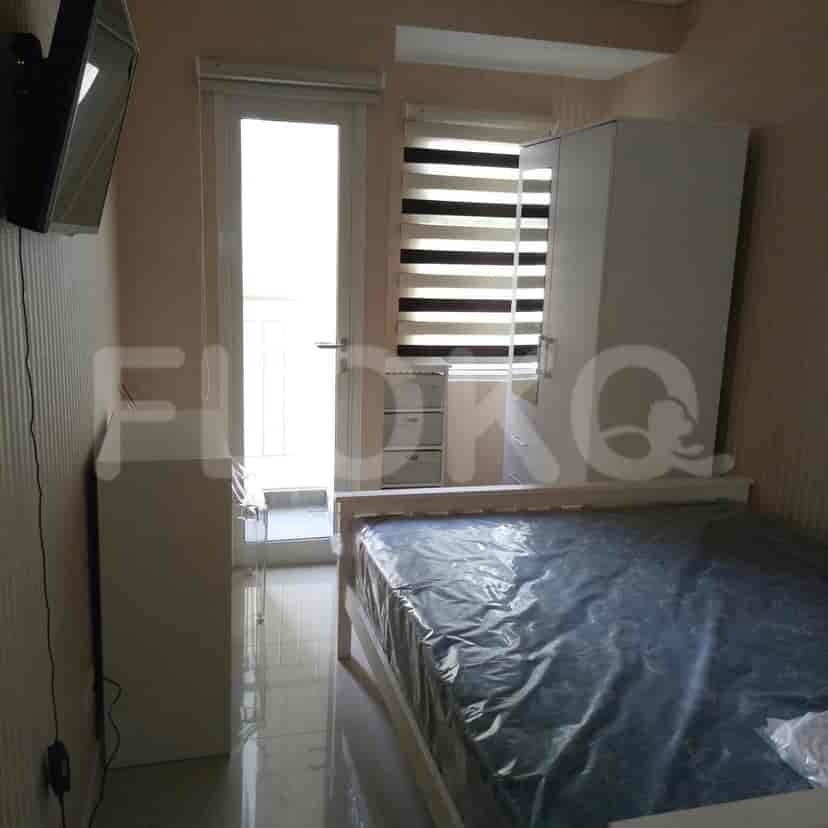 A bedroom with a bed, a wardrobe, and a window with blinds.