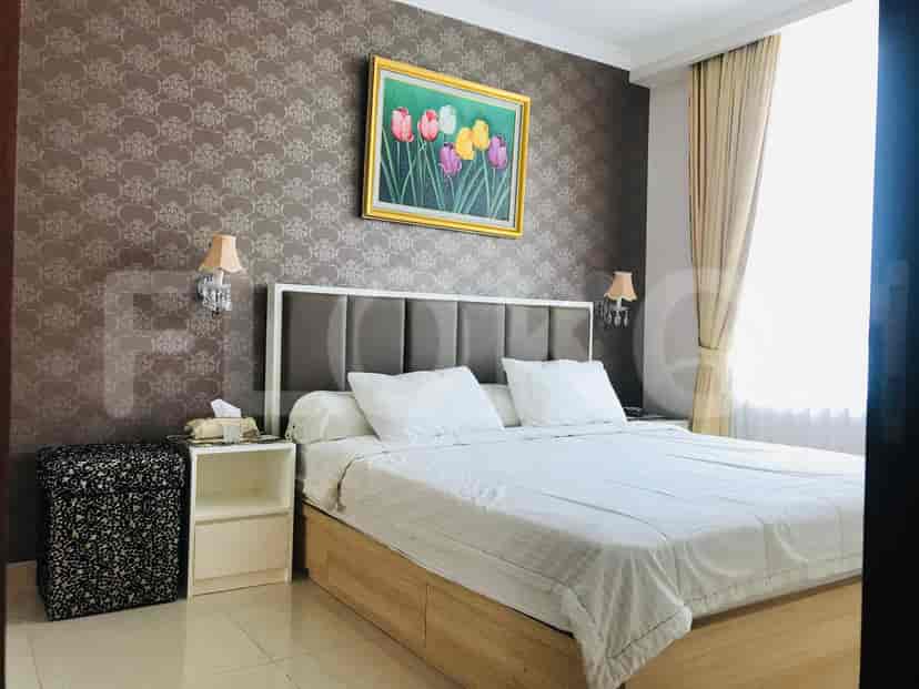 Kamar tidur elegan dengan tempat tidur ukuran king dan dekorasi bergaya.