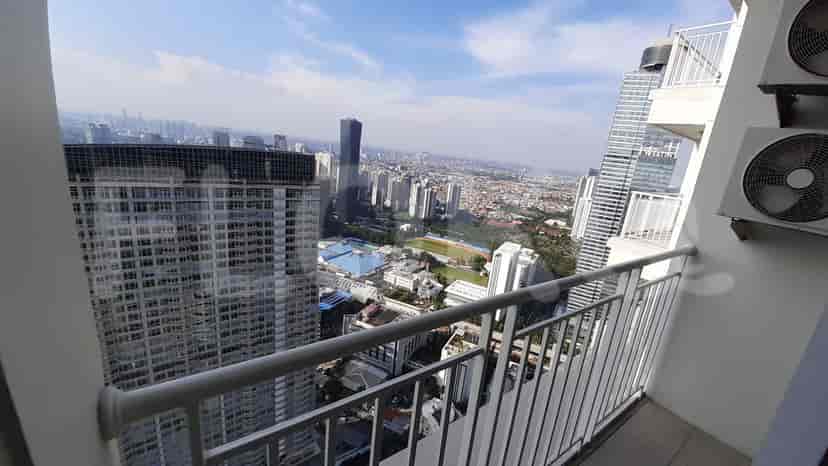 View of a cityscape from a balcony with high-rise buildings.