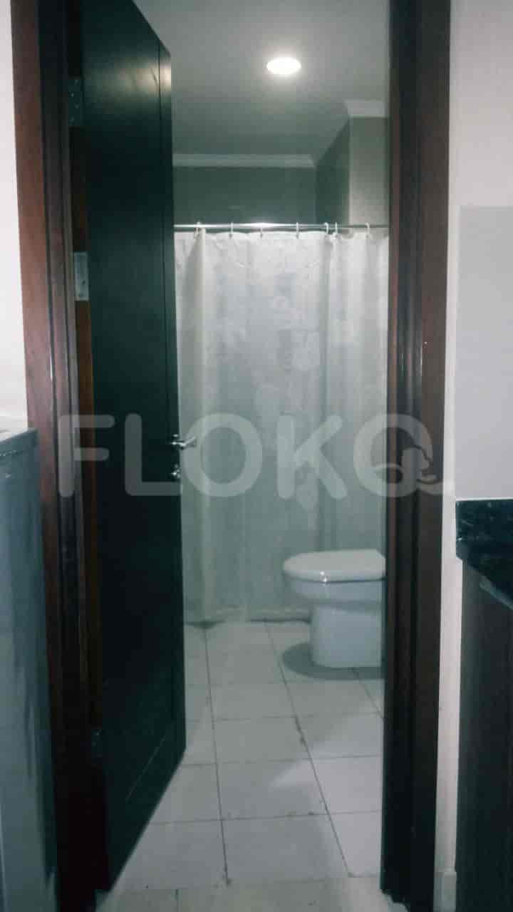 Bathroom with a toilet, shower curtain, and basic white tiles.