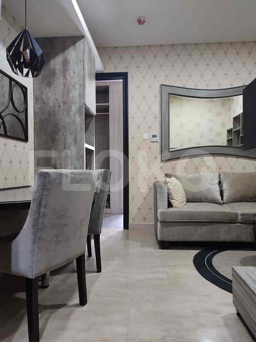 Living room featuring a sofa, dining area, and entrance to other rooms.