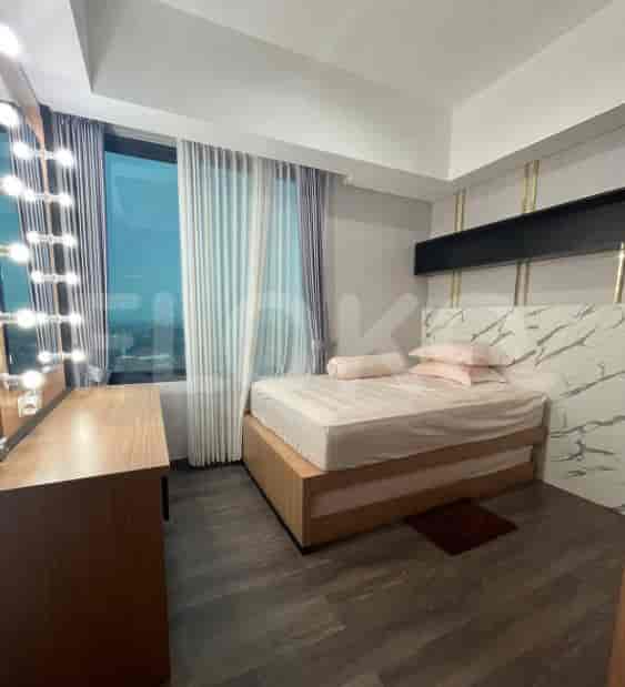 Kamar tidur yang terang benderang dengan tempat tidur ganda, cermin rias, dan meja rias.