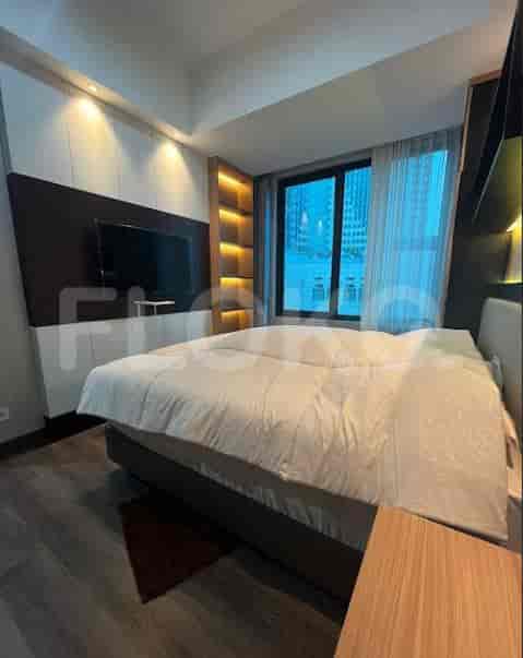 Kamar tidur yang nyaman dengan tempat tidur dan TV yang dipasang di dinding.