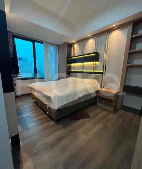 Kamar tidur bergaya dengan tempat tidur, TV, dan meja samping tempat tidur.