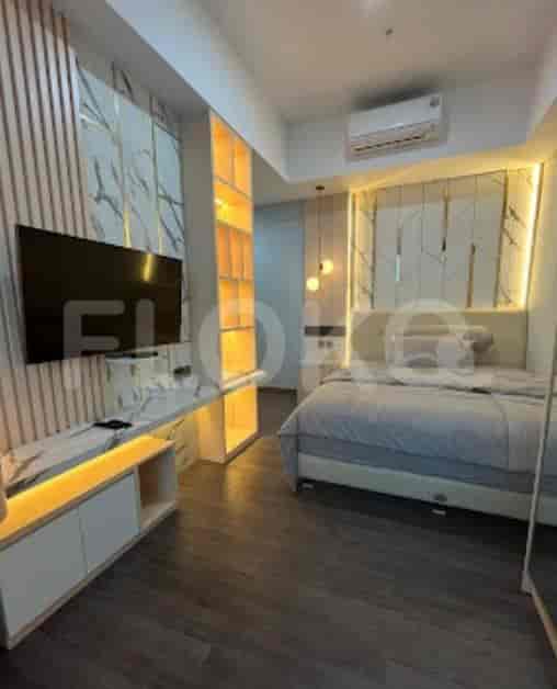 Kamar tidur yang elegan dengan tempat tidur, TV, dan penyimpanan built-in.