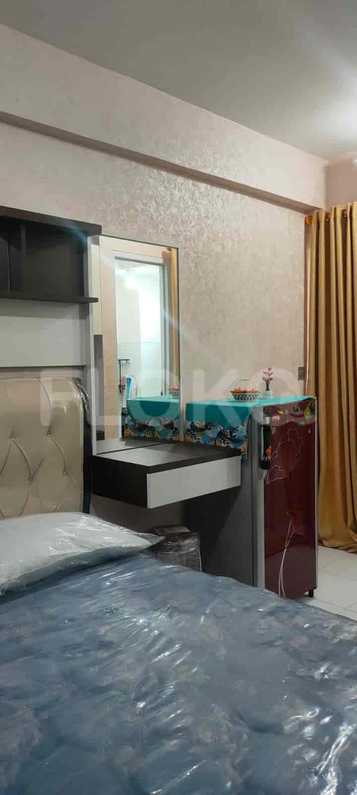 A bedroom with a bed, dressing table, and curtains.